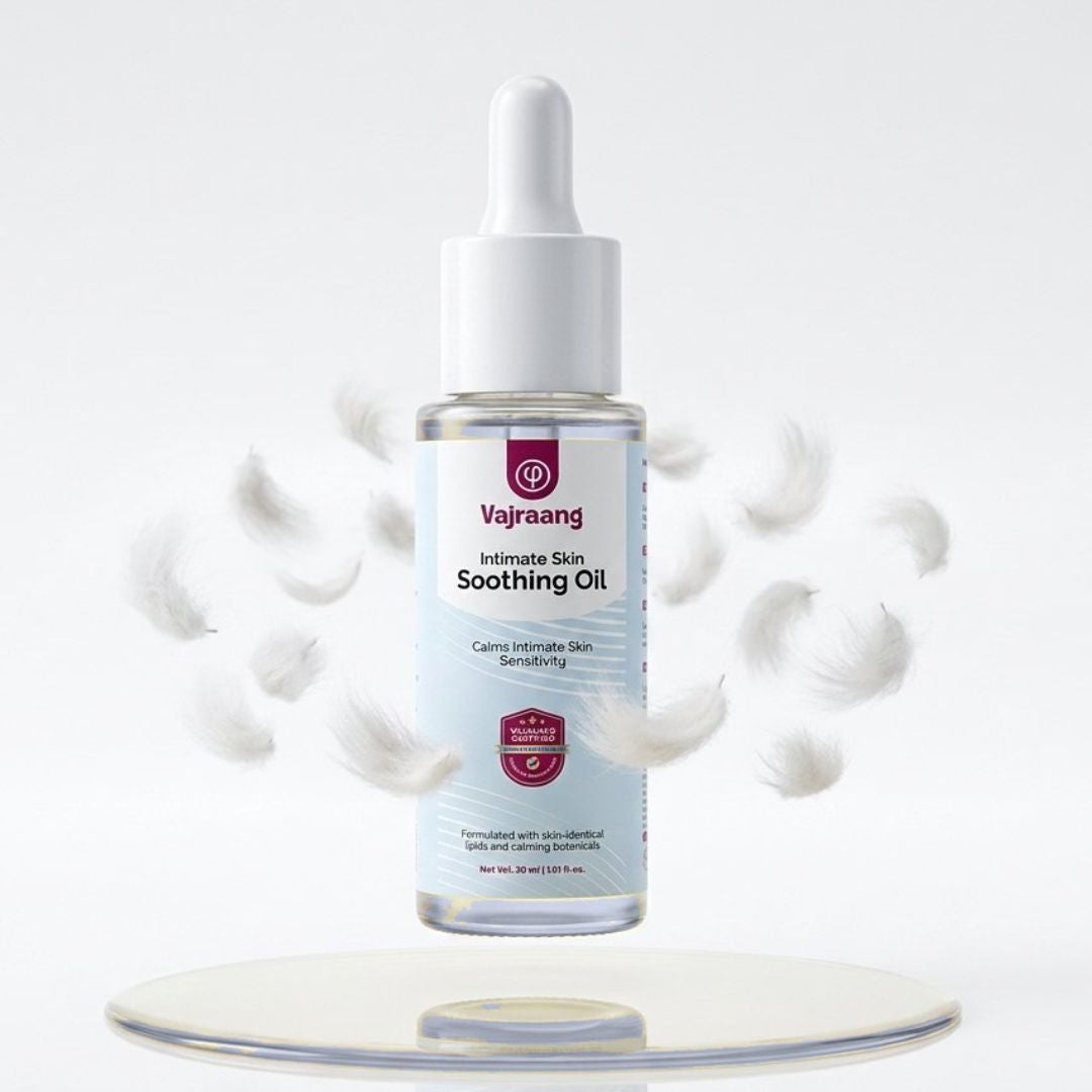 Vajraang Intimate Skin Soothing Oil bottle on a white background with droplets around it.
