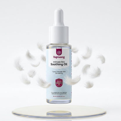 Vajraang Intimate Skin Soothing Oil bottle on a white background with droplets around it.
